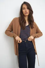 Ruana color tostado de tejido de punto, con corte holgado y diseño básico.