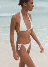 Braga de bikini blanca con textura, corte cheeky y lazos laterales.