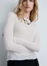 Camiseta blanca de tejido de punto fino con cuello redondo y mangas largas.