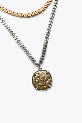 Set de cuatro collares de diferentes largos, con cadenas de eslabones metálicos plateados y dorados. Incluye un choker de eslabones gruesos con medalla central, un collar de eslabones con dijes de medallas labradas, un collar de malla metálica y un collar de eslabones con dije de medalla combinada.