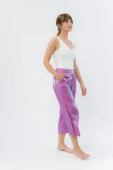 Pantalón de lino con acabado metalizado tornasolado, que refleja tonos entre rosa y lila según la luz. De corte recto y largo ¾, tiene cintura con elástico en la espalda que aporta comodidad y un calce relajado.