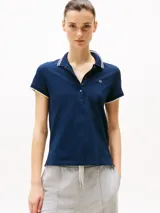 Chomba azul marino de corte slim, confeccionada en algodón elástico. Tiene cuello y mangas ribeteados en blanco, tapeta de cinco botones y logo bordado en el pecho.