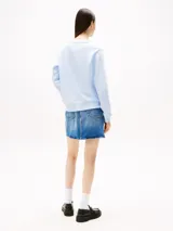 Buzo celeste de cuello redondo, confeccionado en felpa de mezcla de algodón peinado. Tiene cuello, puños y bajo de punto canalé. El logo de Tommy Jeans está bordado en el pecho.