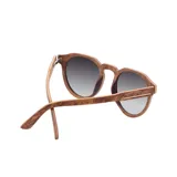 Lentes de sol Indie modelo Ozzy con marco de madera color marrón y lentes grises degradé.