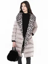 Tapado largo reversible con capucha, un lado con estampado de letras negras sobre fondo beige y otro lado liso color beige.