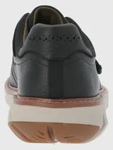 Zapato marrón de cuero con ajuste de velcro y suela gruesa color crema.