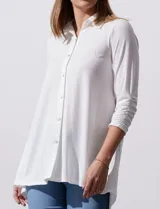 Camisola blanca de manga tres cuartos, marca Rio & Rian. Cuello con solapa y abertura central con botones. Manga con detalle fruncido.