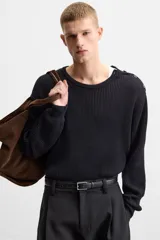 Sweater negro de punto con estructura de canalé, corte relaxed fit, cuello redondo y cierre de botones en el hombro.