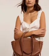 Bolso shopper grande color marrón, con costuras contrastantes, asa de mano y asa larga. Incluye bolsillo interno desmontable.