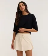 Short pollera color marrón de malla de algodón con cintura elástica y lazo ajustable. Prenda con buenas prácticas ambientales.