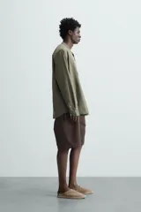 Camisa color beige claro de lino y algodón, corte relaxed fit, cuello mao, manga larga con puños abotonados y cierre frontal con botones. Marca Zara.