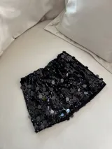 Minifalda negra cubierta de lentejuelas brillantes.