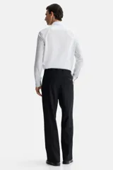 Camisa blanca de corte slim fit, con cuello inglés, tapeta clásica, canesú en la espalda, mangas largas con puños abotonados y bajo levemente redondeado. Confeccionada en tela de fácil planchado.