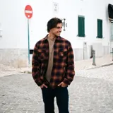 Camisa tipo chaqueta de franela a cuadros marrones y negros, con forro interior de tafeta. Tiene dos bolsillos con tapa en el pecho y dos bolsillos laterales.