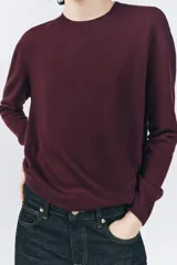 Jersey de punto azul marino confeccionado en 100% lana, de corte recto, con cuello redondo y mangas largas.