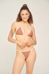 Traje de baño de dos piezas color ladrillo con contorno color crema. El corpiño es de corte triangular con frunce regulable en el centro y copas desmontables. La bombacha es de corte clásico con laterales finos.