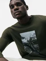 Remera verde militar de manga larga con estampa rectangular frontal de una moto antigua.