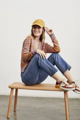 Cárdigan color lila con estampado jacquard en color ocre, con cuello en V, calce al cuerpo y cierre frontal con botones.