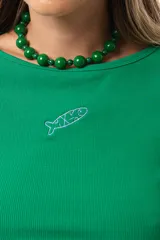 Remera verde de morley suave y elastizado, con calce al cuerpo y cuello redondo. Tiene un pez bordado en el frente.