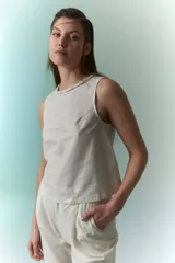 Top sin mangas de lino metalizado color beige, con cuello redondo y detalle trenzado en el borde.