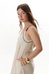 Vestido largo color crudo con breteles finos y costuras a la vista en color azul.