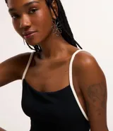 Malla enteriza negra con breteles finos blancos y escote recto.