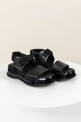 Sandalias negras con plataforma y tiras con textura simil cuero de cocodrilo.