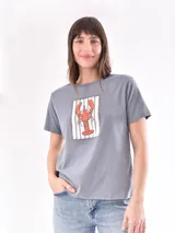 Remera color crudo con estampado de un pez rojo en el frente.