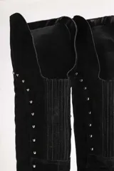 Botas bucaneras negras de gamuza con apliques de tachas doradas.