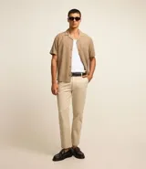 Pantalón de vestir color gris claro, de corte slim fit y largo cropped.