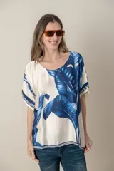 Blusa italiana color natural con estampado de hojas en tonos azules. De calce holgado y talle único.