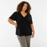 Camiseta negra de punto calado con escote en V y mangas cortas tipo murciélago.
