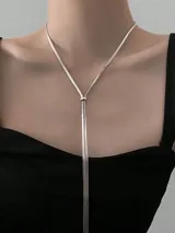 Collar plateado con cadena de eslabones planos y dije colgante con forma de lazo.