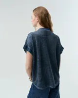 Remera celeste de lino y ramio, con corte boxy, manga japonesa, cuello mao, media cartera con broches metálicos y bolsillo plaqué con efecto de tapa.