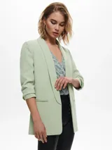 Blazer verde claro con mangas 3/4 y bolsillos frontales.
