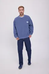 Buzo azul de manga larga y cuello redondo, con calce oversize y logo estampado en el pecho.