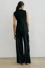 Pantalón recto color crema de lino con costuras laterales en negro.