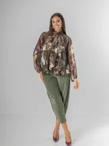 Camisa de seda italiana con estampado floral en tonos rosados, marrones y verdes. Presenta cuello alto con volados que caen en cascada sobre el frente y mangas largas abullonadas con puños ajustados.