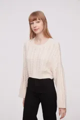 Sweater de punto en color celeste, con diseño de trenzas y mangas largas.