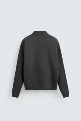 Cárdigan gris oscuro de corte holgado confeccionado en tejido de mezcla de algodón con interior perchado. Presenta cuello en V, manga larga, bolsillos de vivo en la cadera, acabados en rib y cierre frontal con botones.