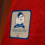 Camiseta de fútbol Umbro del Club Nacional de Football, modelo Away 1 2025. Diseño rojo con detalles en azul en cuello y mangas. Incluye logo de Umbro, escudo del club y sponsors en el frente.