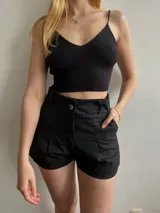 Short negro con cintura alta y bolsillos laterales, diseño ajustado.