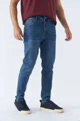 Pantalón de jean gris oscuro, corte carrot, tiro medio, con logo bordado y presillas para cinturón.