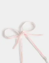 Collar corto de perlas sintéticas con dije de rosa metálica plateada y cierre de cinta de terciopelo negro.