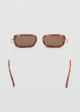 Lentes de sol cuadrados con montura de carey y puente metálico dorado.