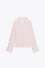Camisa de manga larga color rosa pálido con rayas verticales finas en color marrón, cuello solapa y escote en pico. Cierre frontal con corchetes metálicos.