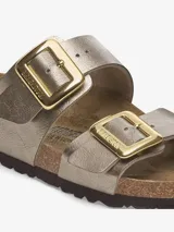 Sandalias Birkenstock modelo Sydney, color dorado metalizado, con dos correas ajustables con hebillas doradas.