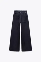 Jeans de tiro alto, pierna ancha y largo al tobillo, en denim celeste claro con efecto lavado. Presenta costura marcada en el centro de cada pierna y cierre frontal con cremallera y botón.