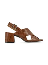 Sandalias negras de charol con tiras cruzadas, tacón cuadrado y pulsera al tobillo con hebilla metálica.