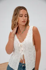 Top tejido color beige con escote en V y tiras finas que se atan en el centro.